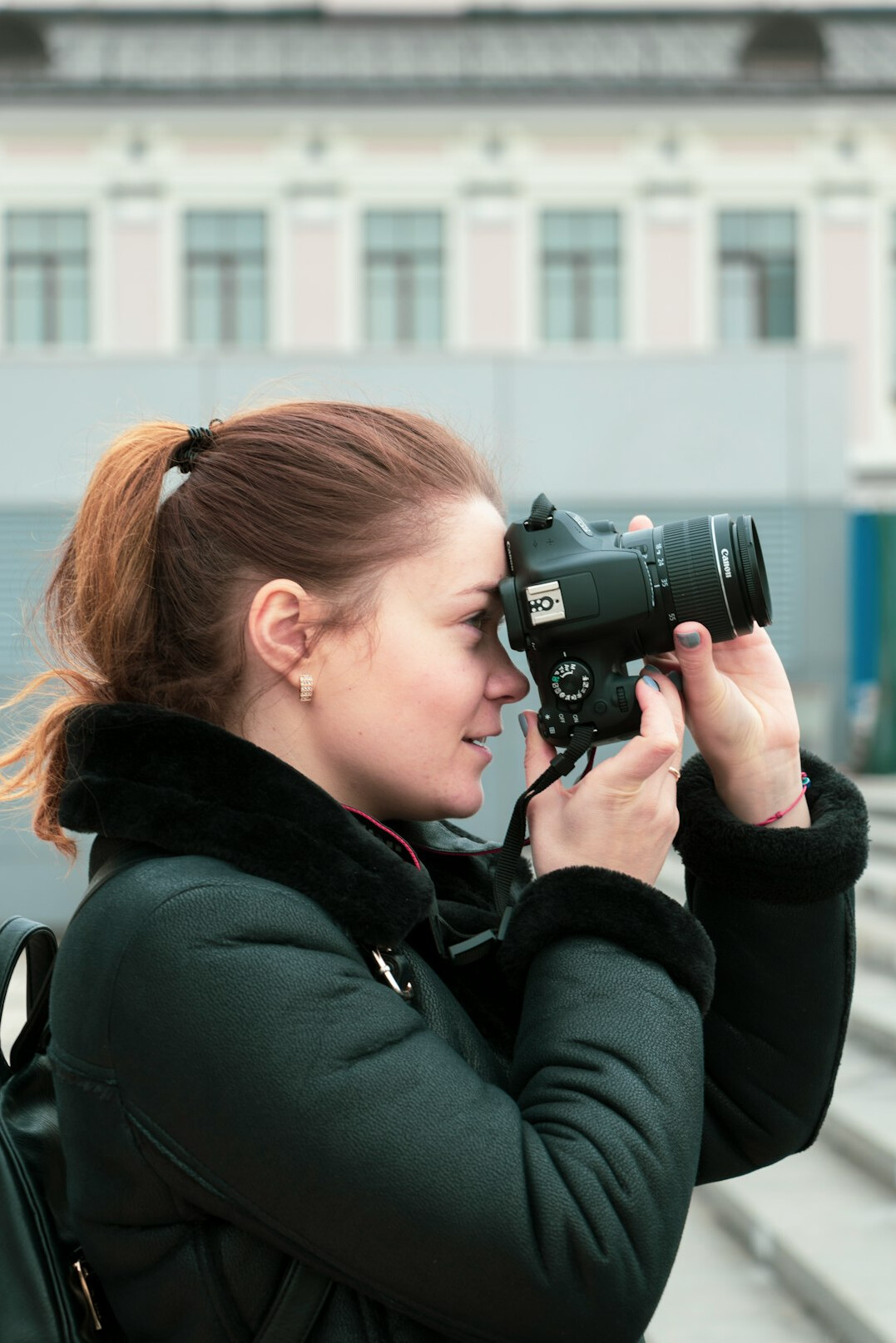 European female camera operator holding a professional camera